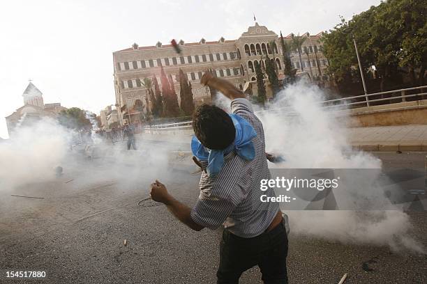 Supporter of the March 14th anti-Syrian opposition coalition lobs a tear gas canister back towards the Lebanese army as he and others try to storm...