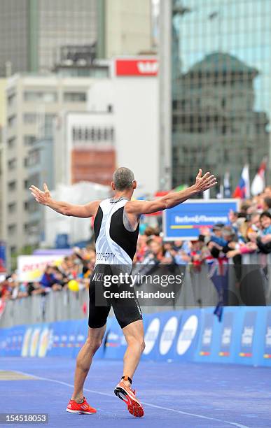 In this handout photo released by the International Triathlon Union, New Zealand's Bevan Docherty salutes the home crowd before finishing 14th at the...