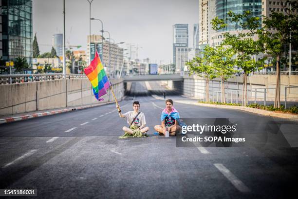 Protestor holds an LGBTQ rainbow flag during a demonstration in Tel Aviv. Tens of thousands of protesters on Tuesday blocked highways and train...