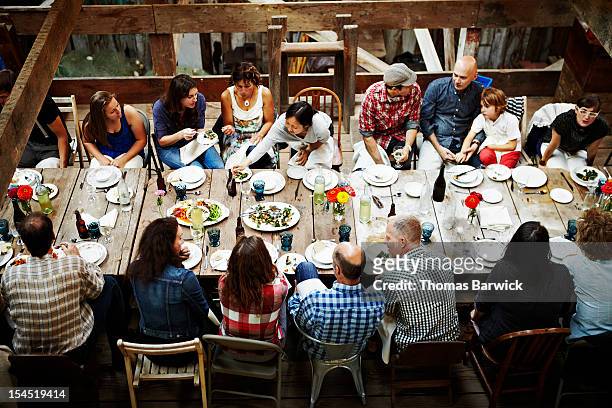 group of friends and family dining overhead view - welvaart stockfoto's en -beelden