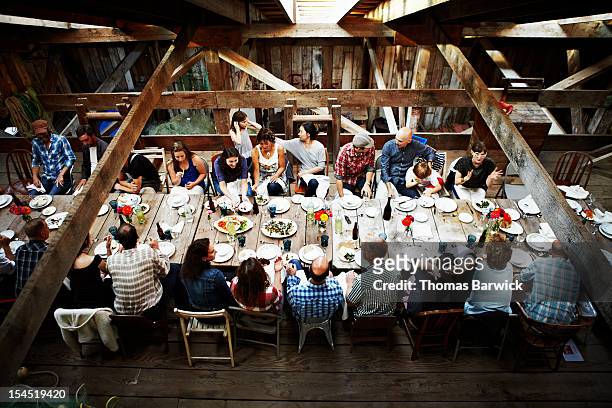 group of friends and family dining overhead view - festmahl stock-fotos und bilder
