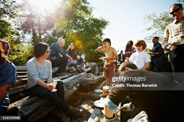 young boy eating oyster with friends and family - large group of people eating stock pictures, royalty-free photos & images