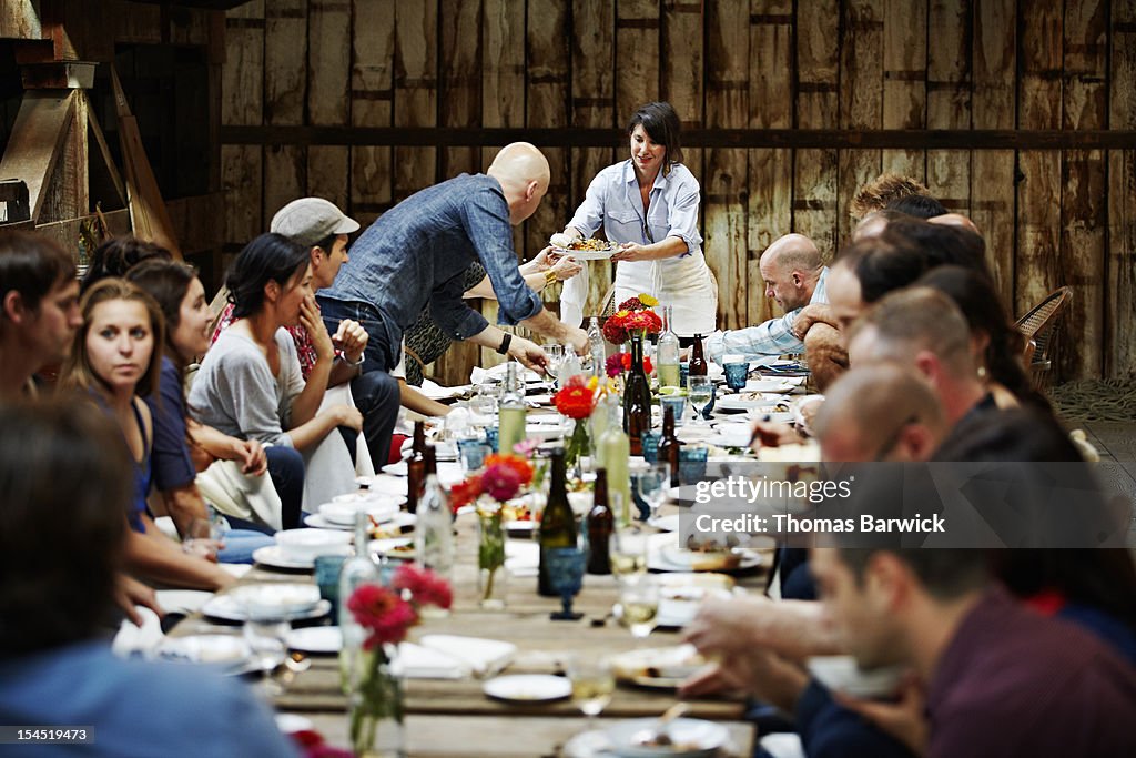 Woman passing food to friends and family