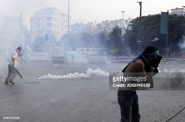 Lebanese supporters of the March 14 movement, which opposes the Syrian regime of President Bashar al-Assad, run for from tear gas fired by Lebanese...