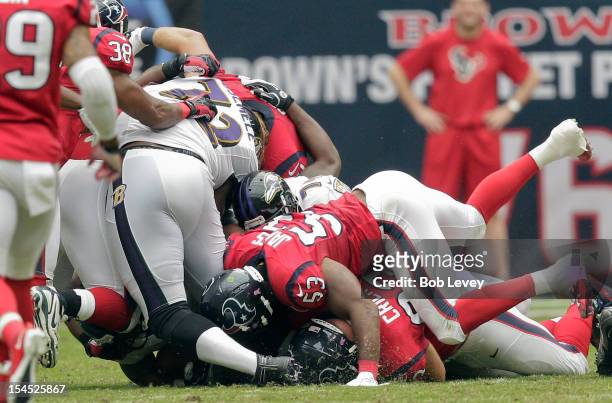 Kelechi Osemele of the Baltimore Ravens has his leg pinned underneath him has Bradie James of the Houston Texans falls on him at Reliant Stadium on...