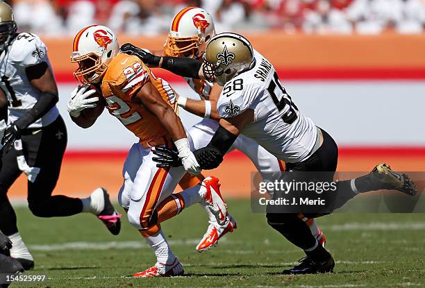 Running back Doug Martin of the Tampa Bay Buccaneers runs out of the grasp of linebacker Scott Shanle of the New Orleans Saints during the game at...