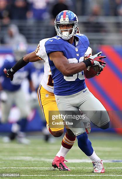 Victor Cruz of the New York Giants carries the ball past Madieu Williams of the Washington Redskins to score the game winning touchdown on October...