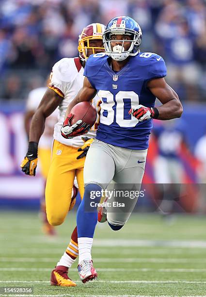 Victor Cruz of the New York Giants carries the ball past Madieu Williams of the Washington Redskins to score the game winning touchdown on October...