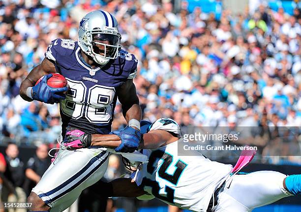 Josh Thomas of the Carolina Panthers dives to tackle Dez Bryant of the Dallas Cowboys during play at Bank of America Stadium on October 21, 2012 in...