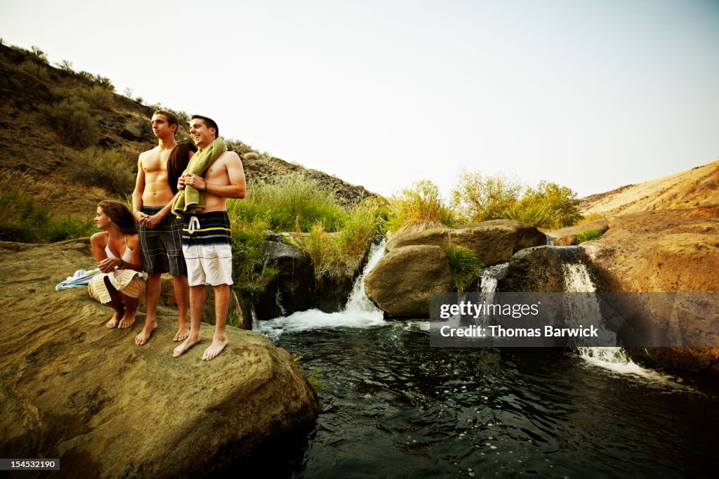 Group of friends on rock near swimming hole