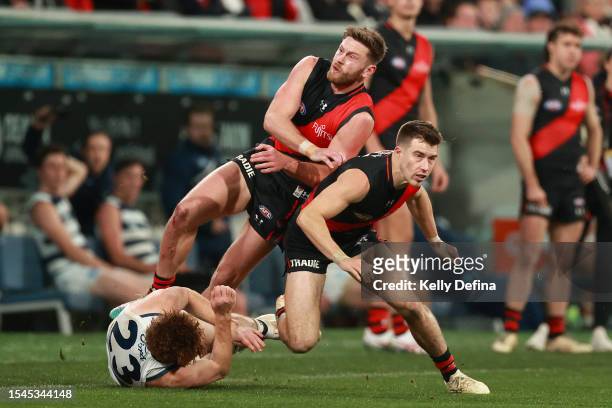Jayden Laverde of the Bombers collides with Gary Rohan of the Cats and Zach Merrett of the Bombers during the round 18 AFL match between Geelong Cats...
