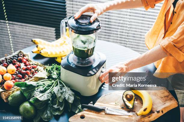 woman making a healthy smoothie. - liquidiser stock pictures, royalty-free photos & images