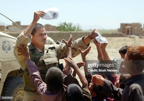 Army Staff Sgt. Rodolfo Arrendondo, from Abilene, TX, hands out flyers from the Army's 345th Psychological Operations Company to a group of local...