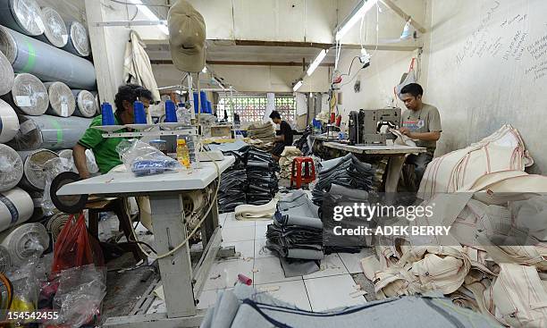 This picture taken on October 21, 2012 shows an Indonesian workers are working at a workshop in a small entreprise village in Jakarta. Indonesia's...