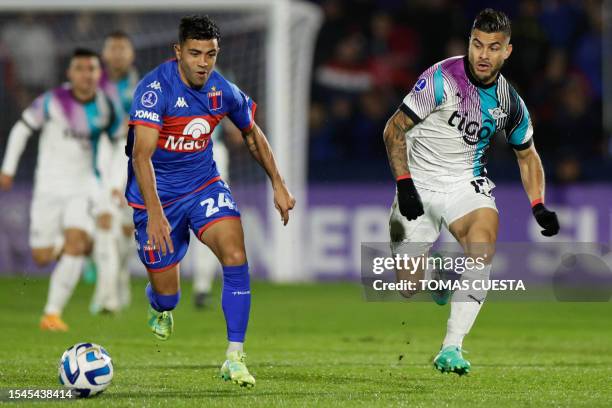 Tigre's defender Martin Garay fights for the ball with Libertad's forward Hector Villalba during the Copa Sudamericana round of 32 knockout play-offs...