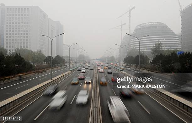 Cars travel on the second ring road as pollution reaches what the US Embassy monitoring station says are "Hazardous" levels in Beijing on December 5,...