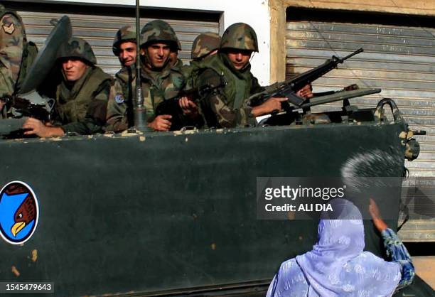Lebanese woman throws rice at Lebanese army soldiers as they arrive to deploy at Fatima Gate in the Lebanese southern village of Kfar Kila, at the...