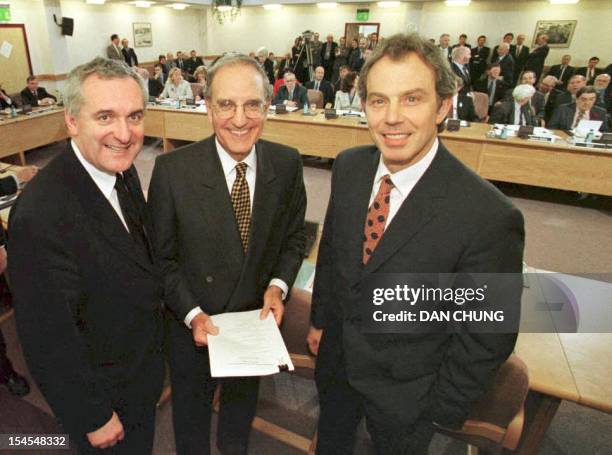 British Prime Minister Tony Blair , US Senator George Mitchell and Irish Prime Minister Bertie Ahern smile,10 April, after they signed an historic...