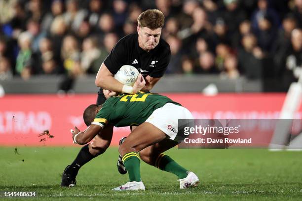 Jordie Barrett of New Zealand is tackled by Manie Libbok of South Africa during The Rugby Championship match between the New Zealand All Blacks and...