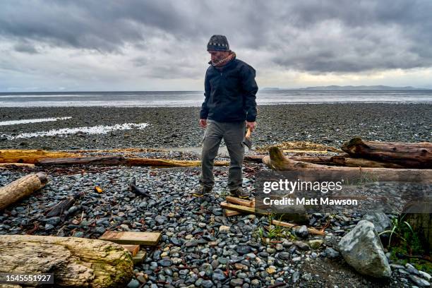 a senior man and his campfire vancouver island bc canada - carmanah walbran provincial park fotografías e imágenes de stock