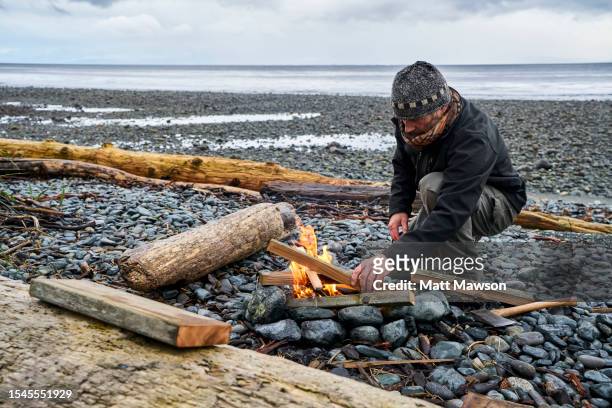 a senior man and his campfire vancouver island bc canada - carmanah walbran provincial park fotografías e imágenes de stock