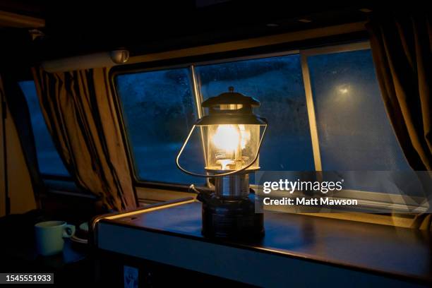 paraffin lamp lighting the interior of a camper van at night while camping on vancouver island bc canada - carmanah walbran provincial park stock pictures, royalty-free photos & images