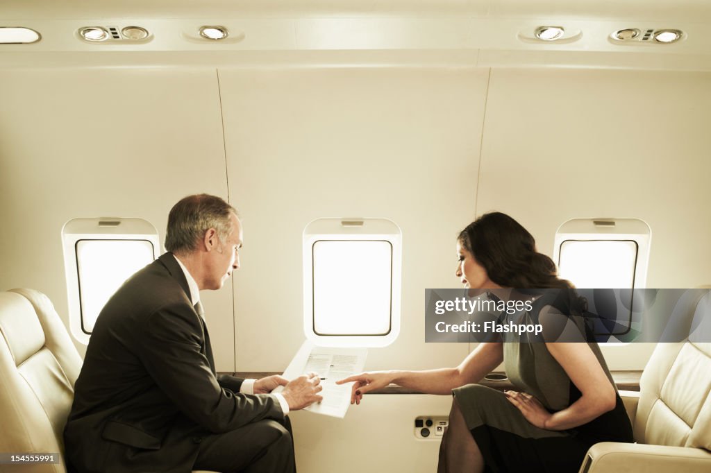 Business executives talking aboard private jet