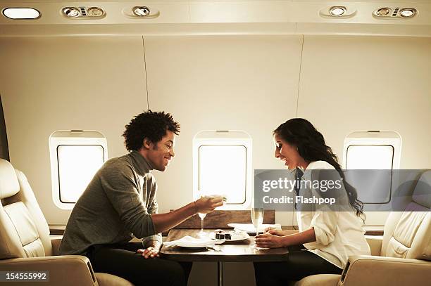 couple enjoying lunch on private jet - airplane food stock-fotos und bilder