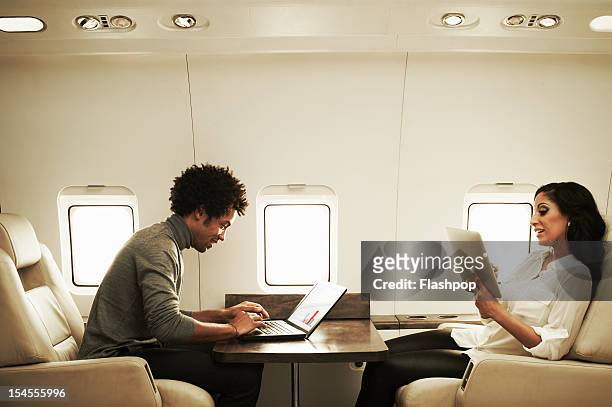 couple relaxing on private jet - millionnaire stock pictures, royalty-free photos & images
