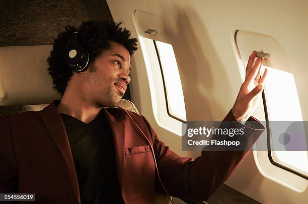 man listening to music on private jet - private aeroplane stock-fotos und bilder
