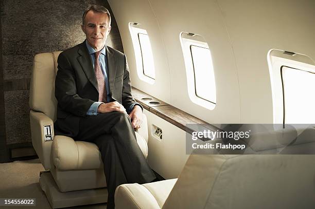 business man travelling aboard a private jet - millionnaire photos et images de collection