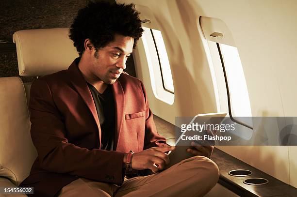 Man using digital tablet on private jet