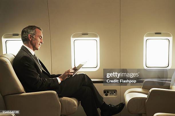 business man travelling aboard a private jet - access photos et images de collection