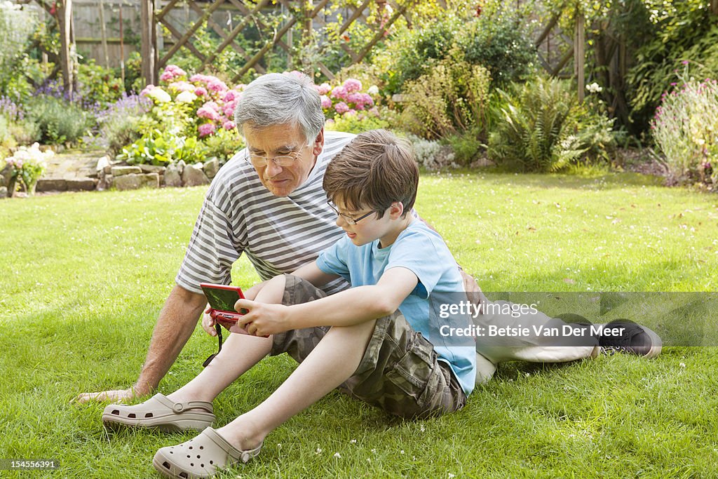 Grandson shows granddad a computer game.