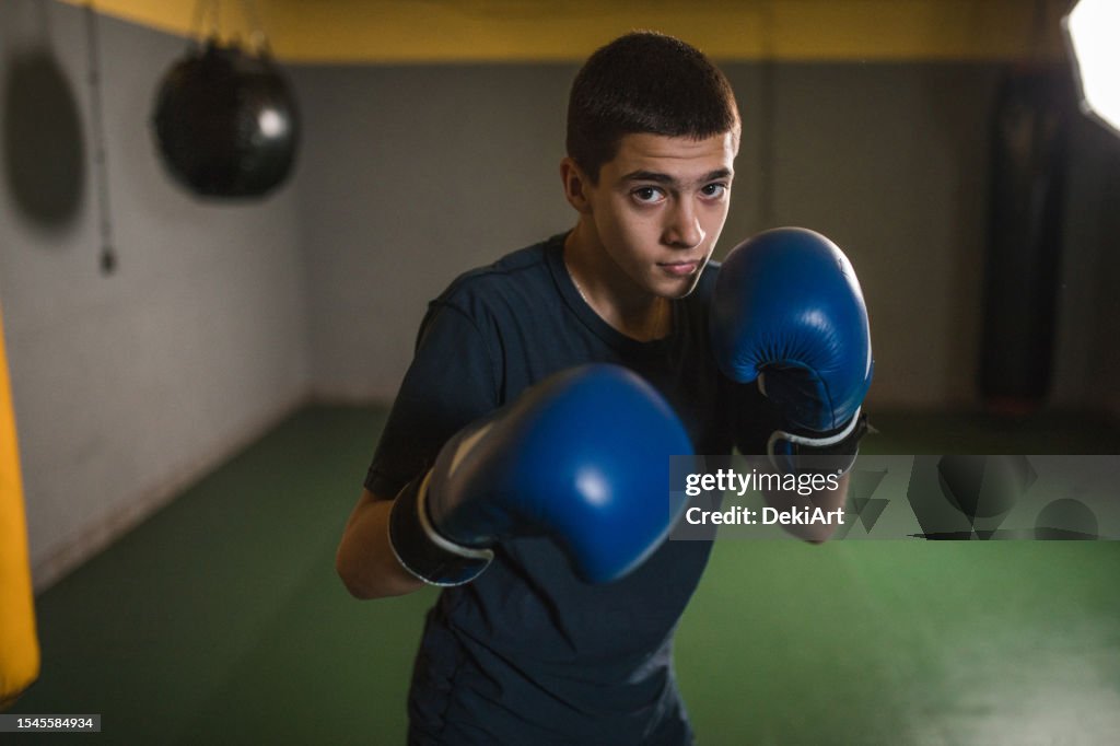 A young handsome kickboxer trains in a boxing gym and prepares for a boxing match