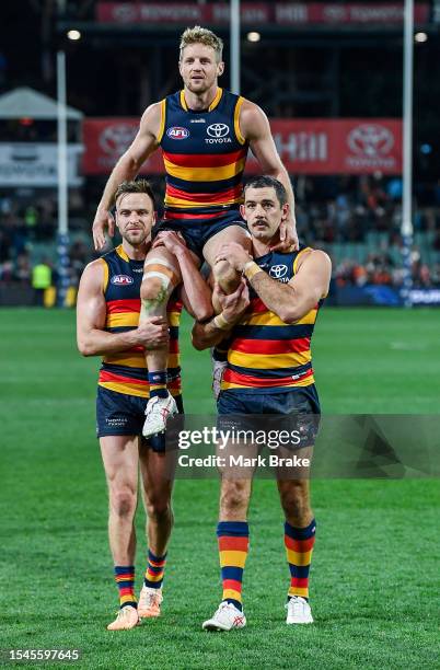 Rory Sloane of the Crows is chaired off by Brodie Smith of the Crows and Taylor Walker of the Crows for his 250th game after the round 18 AFL match...