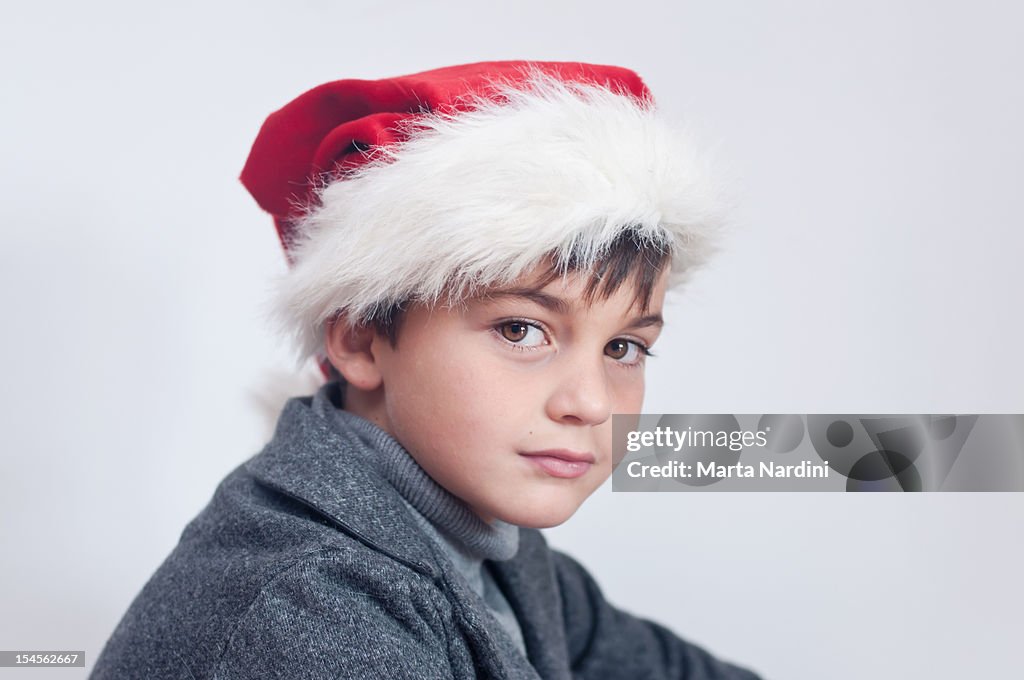 Boy posing n red Christmas Santa hat
