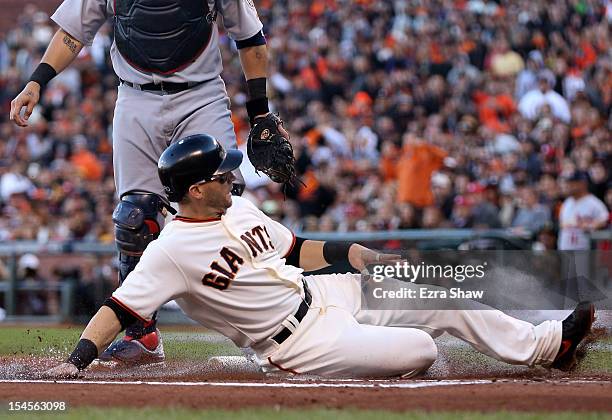 Marco Scutaro of the San Francisco Giants slides home as Scutaro scores in the first inning against the St. Louis Cardinals in Game Six of the...