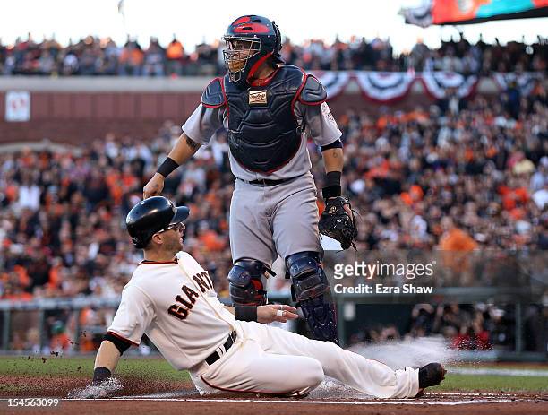 Marco Scutaro of the San Francisco Giants slides home as Scutaro scores in the first inning against the St. Louis Cardinals in Game Six of the...