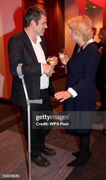 Camilla, Duchess of Cornwall speaks with journalist Paul Conroy, who was with the late Marie Colvin in Syria, as she attends A Hard Calling-Reporting...