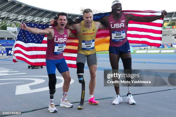 Markus Rehm of team Germany, Derek Loccident and Jarryd Wallace of team United States of America celebration after Mena's Long Jump T63 during day...