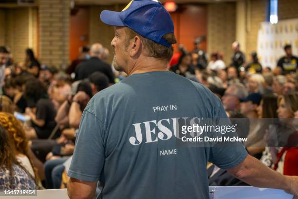 Man wears an evangelical shirt and holds a banner in support of a policy that the Chino Valley school board is meeting to vote on which would require...