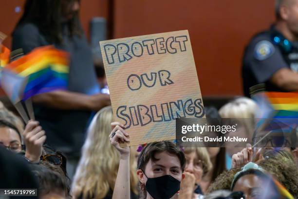 Person holds a sign in opposition to a policy that the Chino Valley school board is meeting to vote on which would require school staff to "out"...