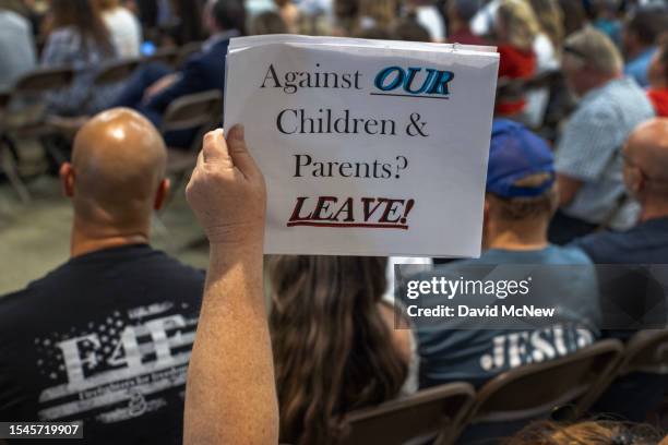 Person holds a sign among a group of people who support a policy that the Chino Valley school board is meeting to vote on which would require school...