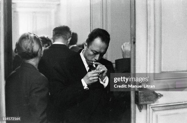 The Nobel Prize in literature has been attributed to Albert Camus: the writer lighting a cigarette between two doors.