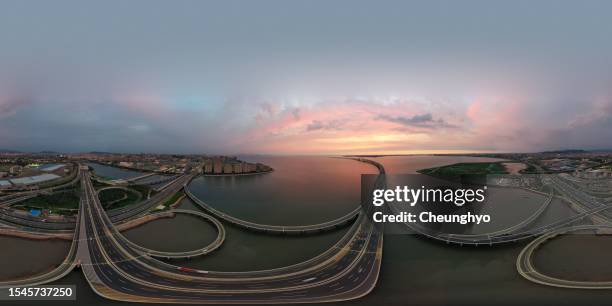 360-degree view: drone aerial view of jiaozhou bay bridge at colorful sunset in qingdao city, shandong province, china - qingdao bridge stock pictures, royalty-free photos & images