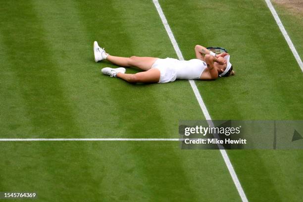 Marketa Vondrousova of Czech Republic falls to the floor as she celebrates winning match point in the Women's Singles Final against Ons Jabeur of...