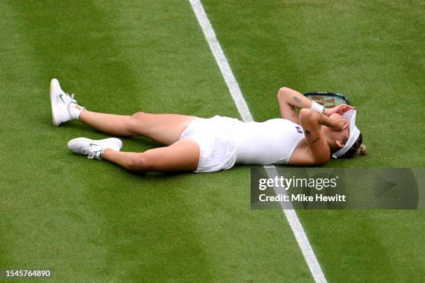 Marketa Vondrousova of Czech Republic falls to the floor as she celebrates winning match point in the Women's Singles Final against Ons Jabeur of...