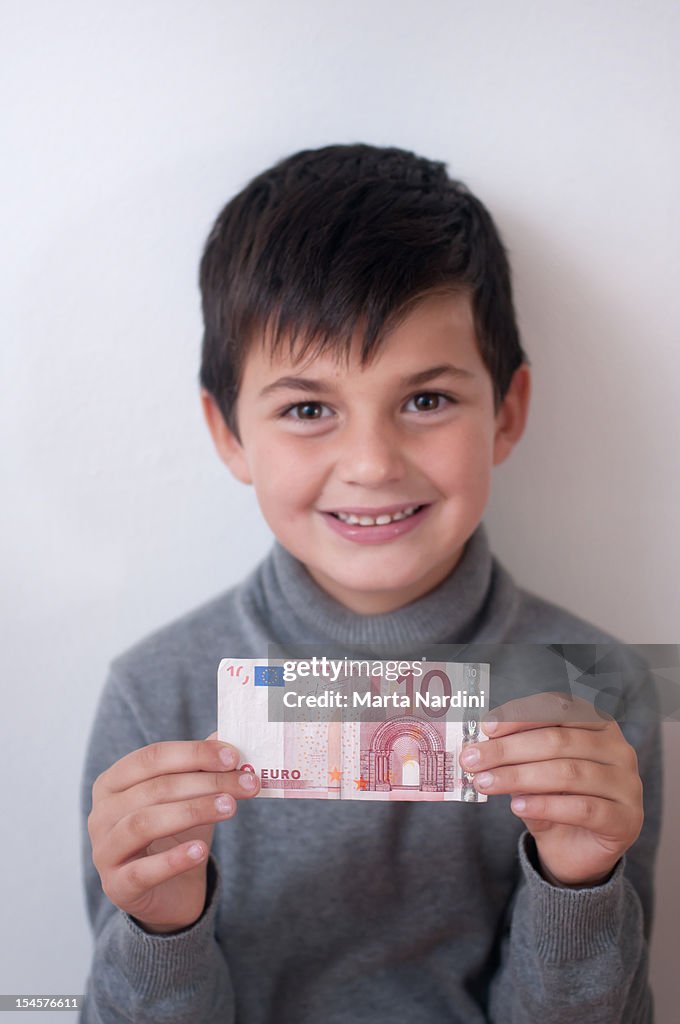 Kid showing a 10 euros banknote