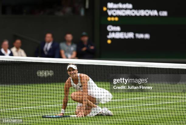 Marketa Vondrousova of Czech Republic falls to the floor as she celebrates winning match point in the Women's Singles Final against Ons Jabeur of...